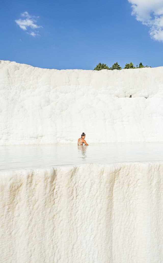 Woman bathing in a pool in the white cliffs of Pamukkale