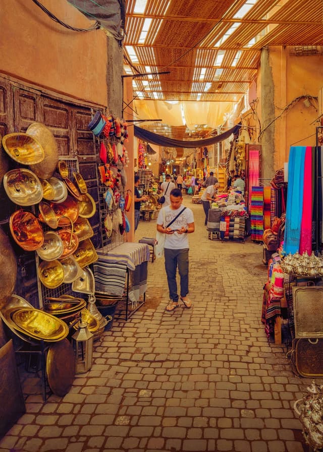 A man walking through a colourful bazaar